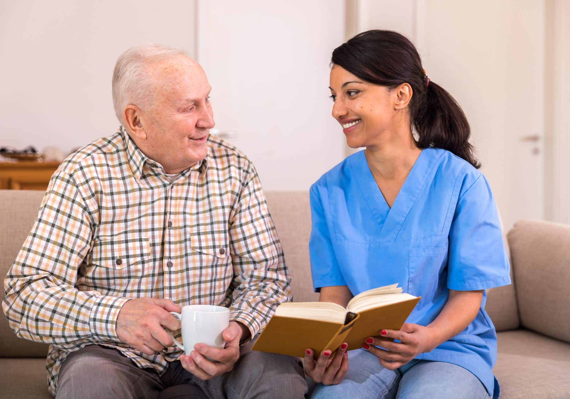 a nurse and an old man sitting on a couch
