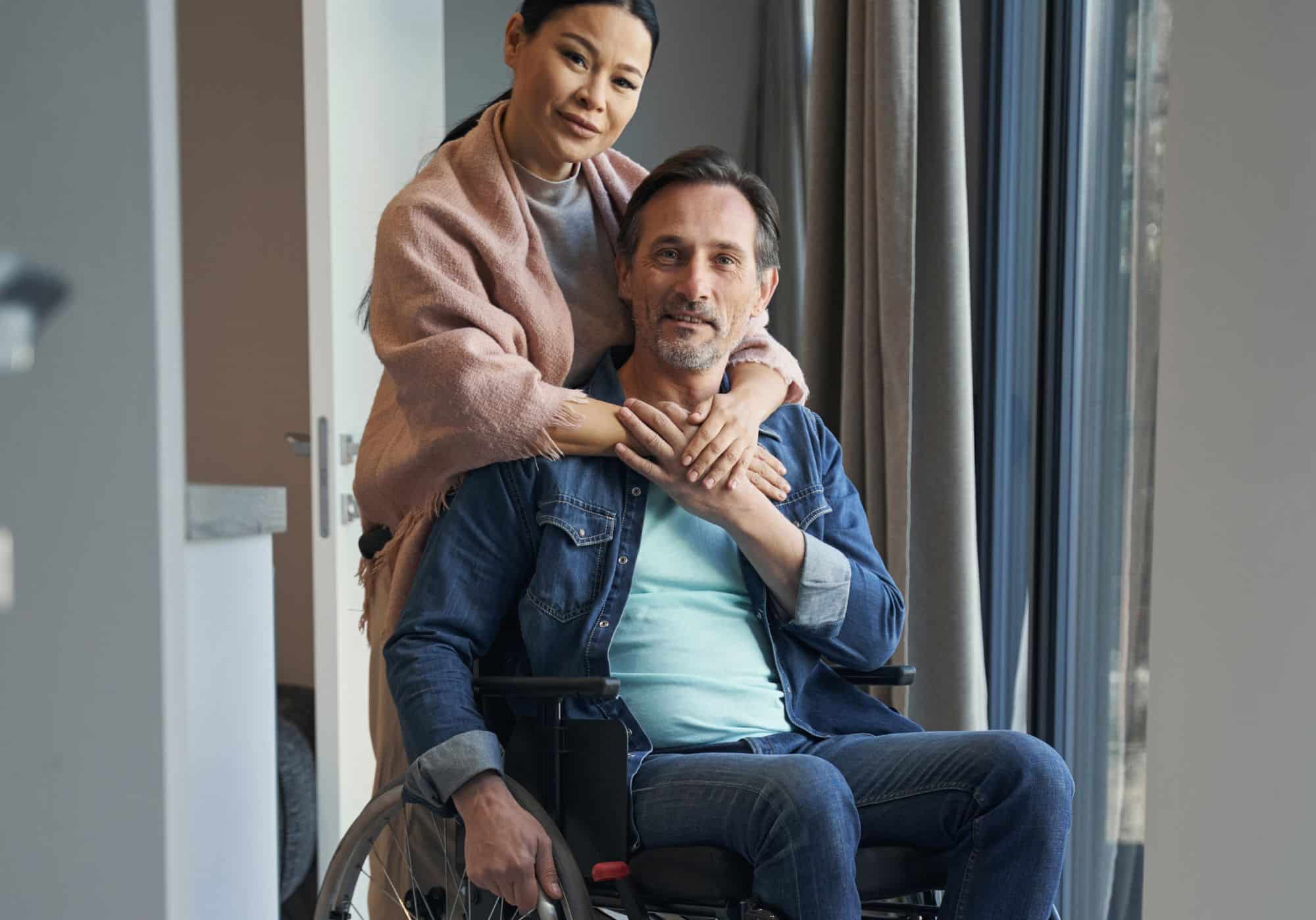 a woman hugging a man in a wheelchair